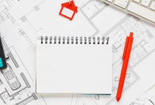 Image d'illustration représentant un amas de plan, un bloc-note, une calculatrice et un clavier d'ordinateur