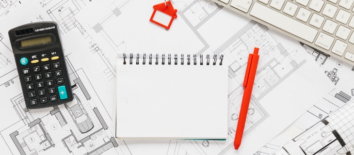 Image d'illustration représentant un amas de plan, un bloc-note, une calculatrice et un clavier d'ordinateur