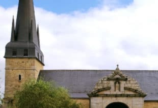 Photographie de l'église de Plescop sous un ciel nuageux