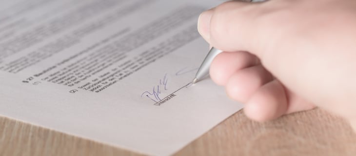 Image d'illustration représentant un contrat en train d'être signé par un homme