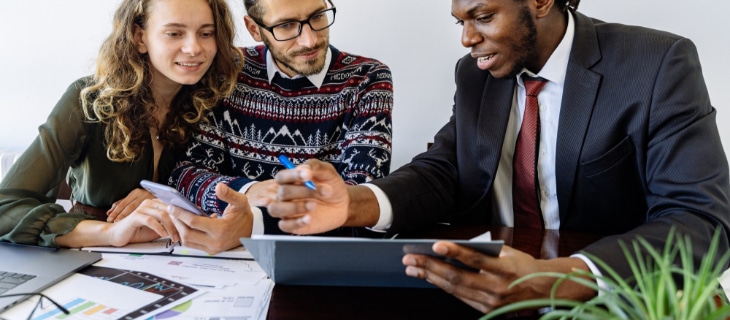 Photographie illustrant 3 personnes qui comparent le TAEG d'offres de prêts immobilier